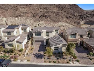 Stunning two-story home in a desert community with a paved driveway and desert landscaping at 30 Hilltop Crest St, Henderson, NV 89011