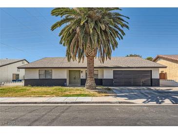 Charming single-story home with a well-manicured front yard and mature palm tree, providing shade and curb appeal at 3047 Van Buskirk Cir, Las Vegas, NV 89121