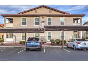 Two-story building featuring assigned covered parking and mature landscaping at 3351 Indian Shadow St # 204, Las Vegas, NV 89129