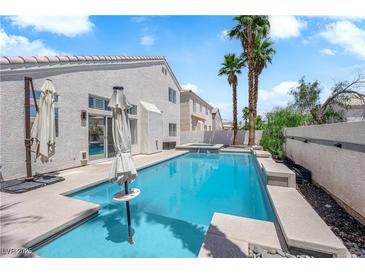 Backyard pool with blue water and palm trees on a sunny day at 4604 Barnes Ct, Las Vegas, NV 89147