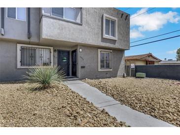 Two story stucco home with desert landscaping and security bars on the first-floor windows at 6008 Pebble Beach Blvd, Las Vegas, NV 89108
