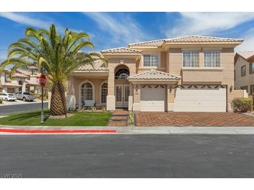 Charming two-story home featuring a well-manicured lawn, a palm tree, and a two-car garage at 8970 Lansberry Ct, Las Vegas, NV 89147