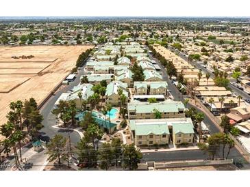 Aerial view of a well-maintained apartment complex with a community pool and green spaces, nestled among tree-lined streets at 1533 Linnbaker Ln # 102, Las Vegas, NV 89110