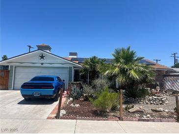 Charming single-story home featuring a desert landscape, blue car, and solar panels on the roof at 6432 Aberdeen Ln, Las Vegas, NV 89107