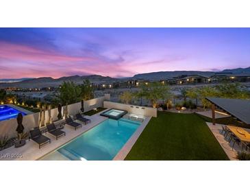 Beautiful pool and patio area with lounge chairs and mountain views at dusk at 12637 Penfield Ave, Las Vegas, NV 89138