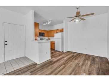 Bright open kitchen with modern appliances, wood cabinets, and hardwood floors in an open floor plan at 1300 S Arlington St # 120, Las Vegas, NV 89104