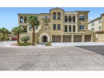 Charming condo building featuring Spanish-style architecture, palm trees, and private garages at 2555 Hampton Rd # 2108, Henderson, NV 89052