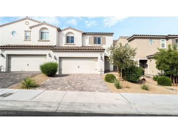 Charming townhome features a neutral color palette, brick driveway and a two-car garage at 285 Rain Quail Way, Henderson, NV 89012