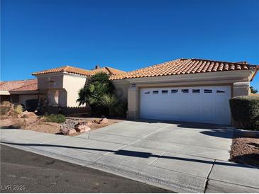 Charming single-story home featuring a tile roof, two-car garage, desert landscaping, and a well-maintained lawn at 3012 Hawksdale Dr, Las Vegas, NV 89134