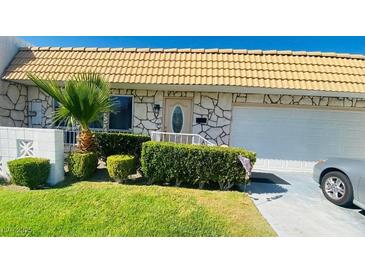 Charming home featuring a well-manicured lawn, desert landscaping, and a tile roof at 3766 Colonial Dr, Las Vegas, NV 89121