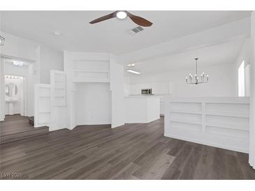 Bright living room features hardwood floors, a ceiling fan, and custom built in shelving at 4807 Leadership Ct, North Las Vegas, NV 89031