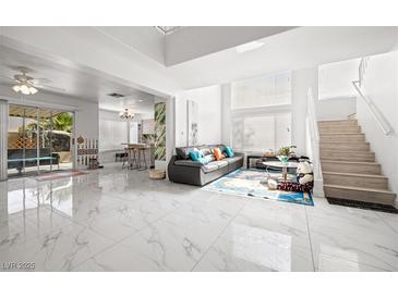 Bright, open-concept living room with high ceilings, modern decor, and ample natural light at 5332 Desert Blossom Rd, Las Vegas, NV 89107