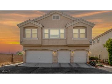 Charming two-story home featuring a triple garage and inviting curb appeal set against a vivid sunset sky at 9312 Straw Hays St # 103, Las Vegas, NV 89178