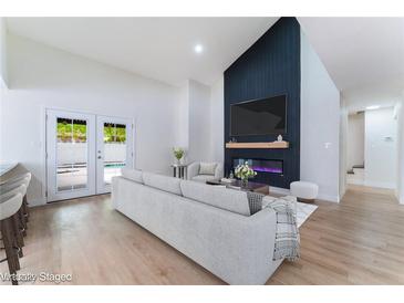 Bright living room featuring a fireplace, modern furnishings, and patio access to the backyard pool at 3409 El Cortez Ave, Las Vegas, NV 89102
