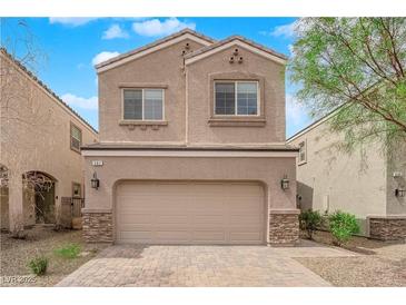 Charming two-story home with a beige exterior, stone accents, and a spacious two-car garage at 367 Wilford Springs St, Henderson, NV 89014