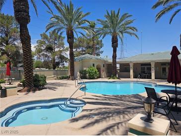 Community pool and spa area featuring palm trees, seating, and well-maintained facilities on a sunny day at 5155 W Tropicana Ave # 2140, Las Vegas, NV 89103