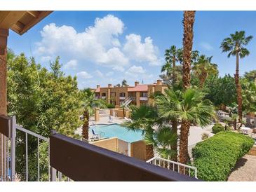 Relaxing condo community featuring a sparkling pool, mature palm trees, and well-maintained landscaping at 5166 S Jones Blvd # 205, Las Vegas, NV 89118