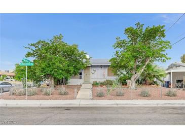 Charming single-story home with mature trees, desert landscaping, and a chain-link fence at 601 Huntington St, Las Vegas, NV 89107