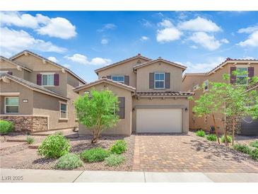 Charming two-story home featuring a brick driveway, manicured lawn and neutral color palette at 69 Ella Ashman Ave, Henderson, NV 89011