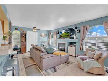 Cozy living room with a fireplace, large windows, and comfortable seating arrangement at 7950 W Flamingo Rd # 1003, Las Vegas, NV 89147