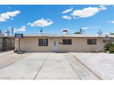 Single-story home with a concrete driveway, white gravel accents, and a basketball hoop for recreational fun at 808 Reynolds Ave, North Las Vegas, NV 89030