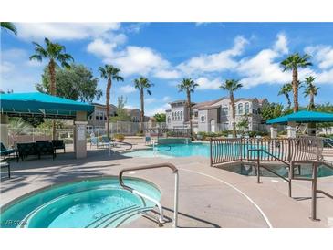 Resort-style community pool and spa area with palm trees and seating under shaded canopies at 9975 Peace Way # 1069, Las Vegas, NV 89147