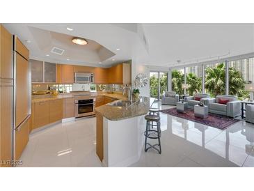 Open concept kitchen with stainless appliances and granite countertops flows into the living room at 322 Karen Ave # 308, Las Vegas, NV 89109
