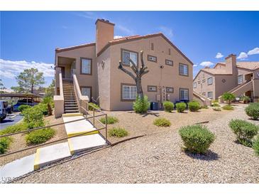 Two-story condo featuring well-maintained landscaping and exterior stairs to the upper-level units at 3455 Erva St # 112, Las Vegas, NV 89117