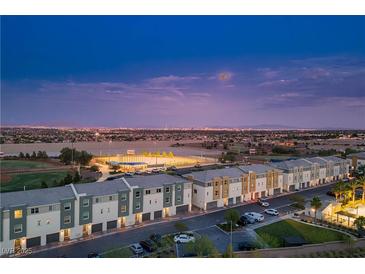 Stunning aerial view of modern townhomes, baseball fields, and the city skyline at dusk at 3880 Enchanted Sky St, Las Vegas, NV 89129