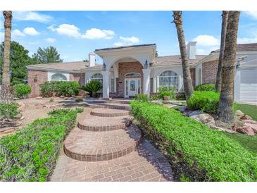 Charming single-story home with manicured landscaping, brick accents, and a welcoming entrance with brick steps at 4418 Desert Bloom Ct, Las Vegas, NV 89129