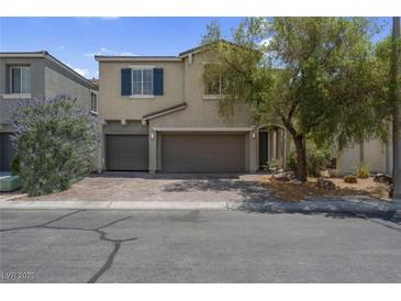 Inviting two-story home featuring a well-maintained front yard, dual-car garage and cozy curb appeal at 9840 Chief Sky St, Las Vegas, NV 89178