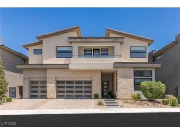 Stunning two-story home with a neutral color palette, three-car garage and manicured front yard at 10748 Steel Ridge Ct, Las Vegas, NV 89135