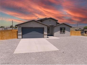 Charming single-story home featuring a two-car garage, gravel landscaping, and inviting neutral-toned exterior at 1500 E Laguna St, Pahrump, NV 89048