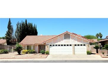 Charming single-story home featuring a red tile roof, three-car garage, and desert landscaping at 1536 Brocado Ln, Las Vegas, NV 89117