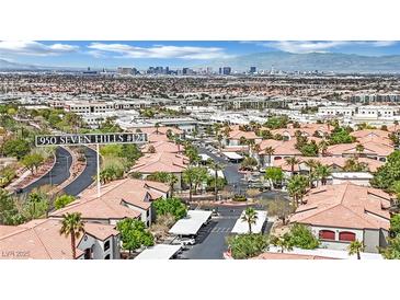 Community aerial view of red tile roofs and landscaping, with the Las Vegas skyline in the distance at 950 Seven Hills Dr # 124, Henderson, NV 89052