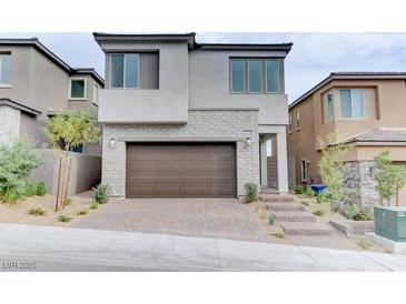 Modern two-story home featuring a brick-accented facade, dark brown garage door, and landscaped front yard at 11840 Pelican Butte Ave, Las Vegas, NV 89138