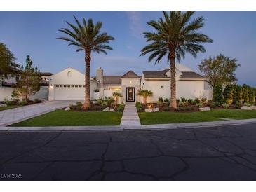 Stunning single-story home with a circular driveway, lush landscaping, and mature palm trees at 11926 Port Labelle Dr, Las Vegas, NV 89141