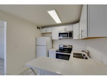 Bright kitchen features white cabinets, stainless steel appliances, and quartz countertops at 212 Orland St # 28, Las Vegas, NV 89107