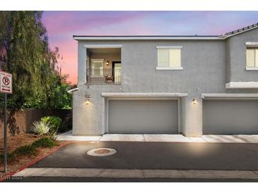 Charming two-story townhome featuring a private balcony and attached two-car garage with a stucco facade at 2860 Sunflower Days Ave # 2141, North Las Vegas, NV 89031