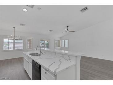 Bright kitchen features a breakfast bar with stunning marble countertops and stainless steel appliances at 5808 Spinnaker Reach Ave, Las Vegas, NV 89130