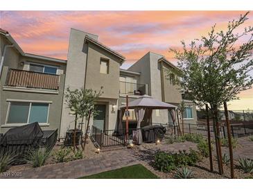 Charming townhome features a cozy patio area with a gazebo, perfect for outdoor dining and relaxation at sunset at 6807 Satin Silver Ct, North Las Vegas, NV 89086