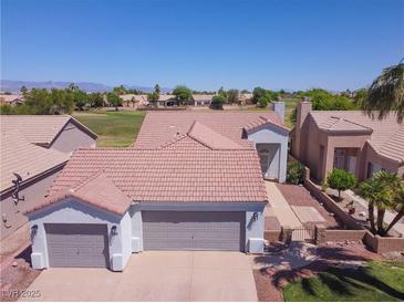 Charming home featuring a well-manicured lawn, desert landscaping, and an attached two-car garage at 1195 Golf Club Dr, Laughlin, NV 89029