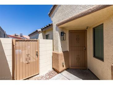 View of the front entrance featuring a decorative metal security door and adjacent gated entrance to the private front courtyard at 1905 Eskam St, Las Vegas, NV 89156