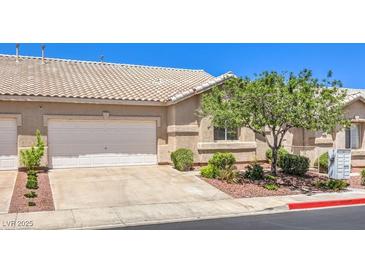 Charming home featuring a two-car garage, desert landscaping, and a tile roof at 201 Teller St, Henderson, NV 89074