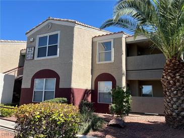 Two-story condominium featuring an attractive paint scheme and a well-maintained landscape, with a mature palm tree at 5055 W Hacienda Ave # 2102, Las Vegas, NV 89118