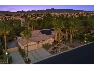 Expansive desert home with solar panels, tile roof, and tropical landscaping overlooking the city and mountains at 10674 Chillingham Dr, Las Vegas, NV 89183