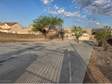 Spacious vacant lot featuring native trees, shrubs, and a long concrete driveway at 1345 N Hollywood Blvd, Las Vegas, NV 89110