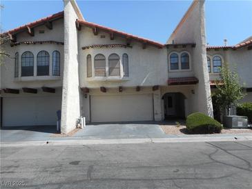 Charming townhome featuring a stucco exterior, a red tile roof, and attached garages at 5006 Schumann Dr, Las Vegas, NV 89146