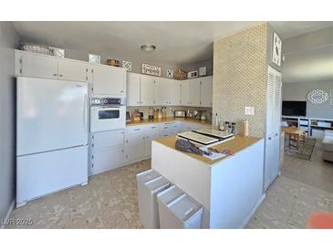 Bright kitchen features white cabinetry, wood countertops, and updated appliances at 5704 Heron Ave, Las Vegas, NV 89107