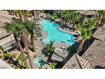 An aerial view of a sparkling community pool with lounge chairs and palm trees at 7119 S Durango Dr # 211, Las Vegas, NV 89113